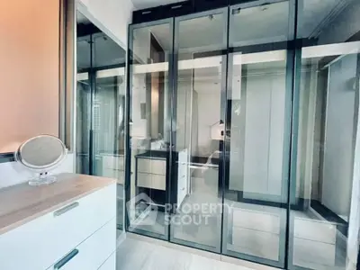 Modern bedroom with sleek glass wardrobe and stylish dresser
