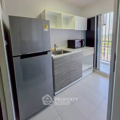 Modern kitchen with sleek appliances and balcony view in a stylish apartment.