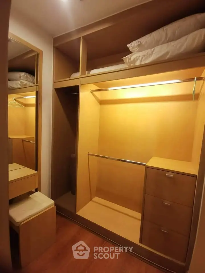 Spacious walk-in closet with ample storage and elegant wooden finish.