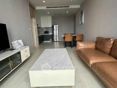 Modern living room with leather sofa and marble coffee table in open layout apartment.