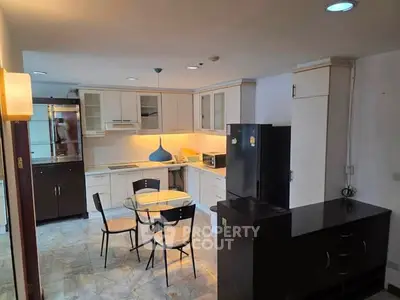 Spacious kitchen with modern appliances and dining area in a stylish home.