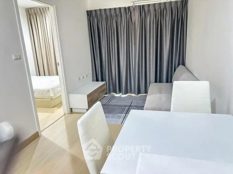 Modern apartment interior with cozy living room and adjacent bedroom, featuring stylish furniture and neutral tones.