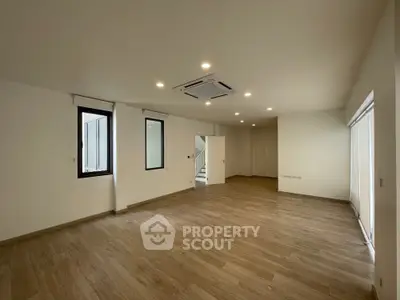 Spacious modern living room with wooden flooring and recessed lighting