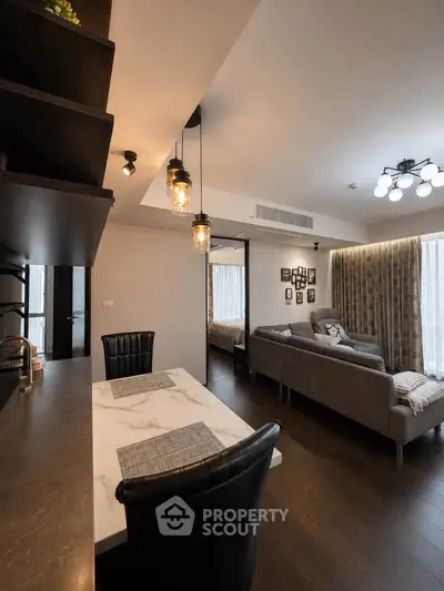 Modern living room with stylish decor and open layout, featuring cozy seating and elegant lighting.