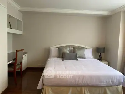 Spacious bedroom with elegant decor and built-in desk, perfect for comfort and productivity.