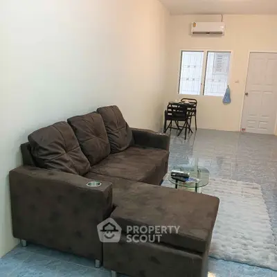 Cozy living room with plush brown sofa and modern decor in a bright apartment.