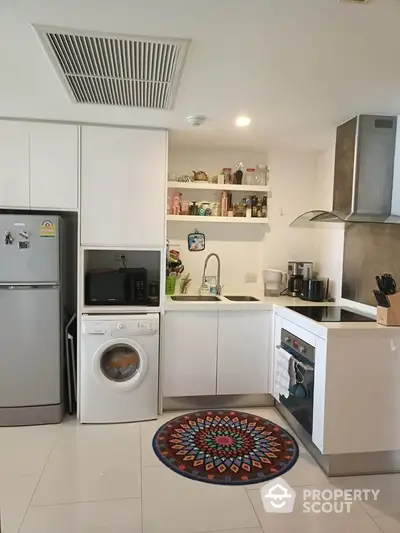 Modern kitchen with washing machine and oven in sleek white design