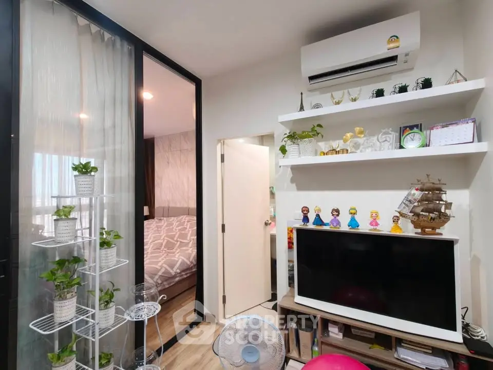 Modern apartment interior with cozy bedroom and stylish living area featuring TV and air conditioning.