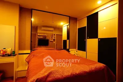 Cozy bedroom with warm lighting and stylish decor, featuring a large mirror and ample storage space.