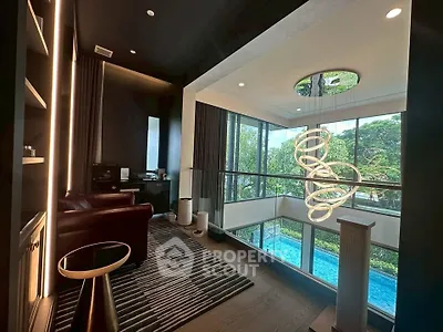 Luxurious modern living room with high ceilings and pool view, featuring elegant lighting and stylish decor.