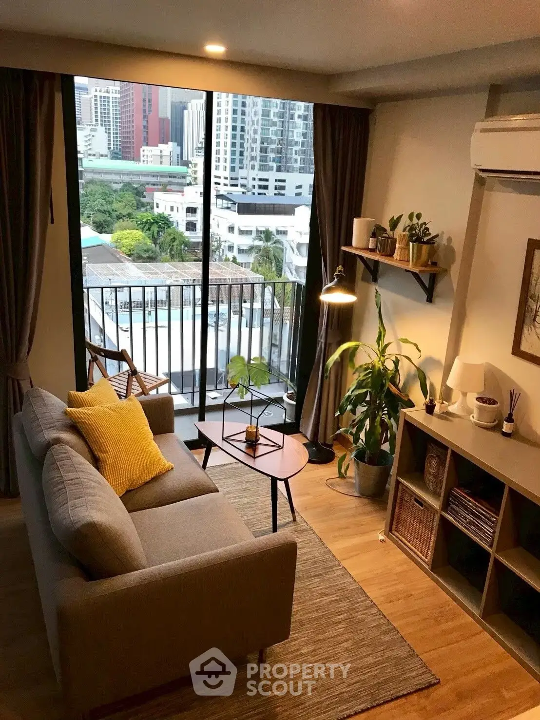 Chic living room with balcony view in modern apartment, featuring cozy decor and abundant natural light.