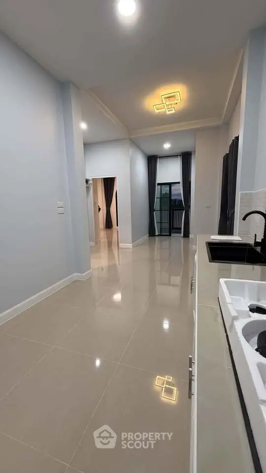 Spacious modern apartment interior with sleek kitchen and elegant lighting.
