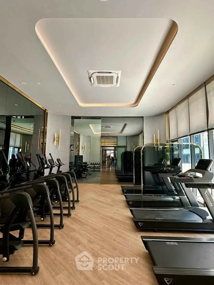 Modern gym with state-of-the-art equipment and stylish interior design in luxury residential building.