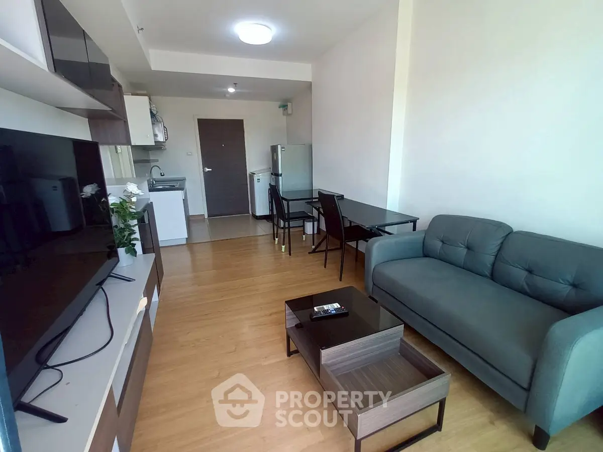 Modern living room with sleek furniture and open kitchen layout, perfect for urban living.