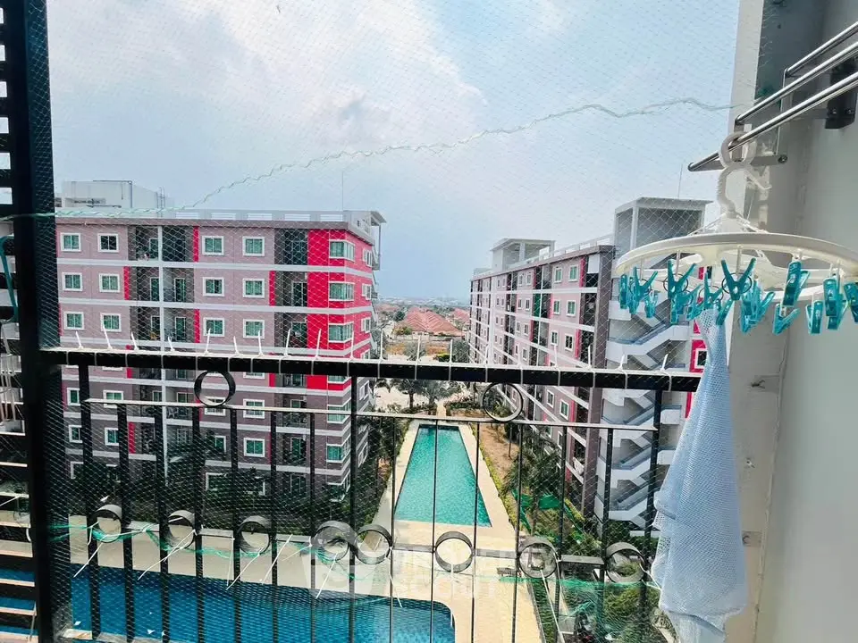 Stunning balcony view of modern apartment complex with pool and cityscape.