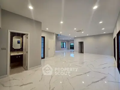 Spacious modern living area with marble flooring and recessed lighting