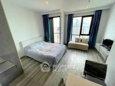 Modern bedroom with large windows and city view in high-rise apartment