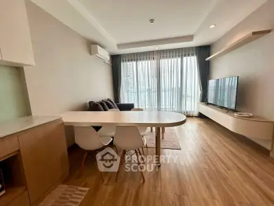 Modern living room with sleek furniture and large windows offering natural light.