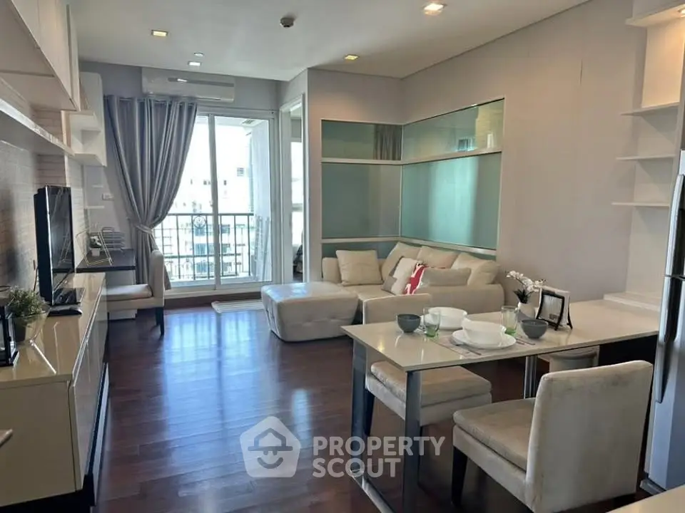 Modern living room with stylish decor and balcony view in a contemporary apartment.