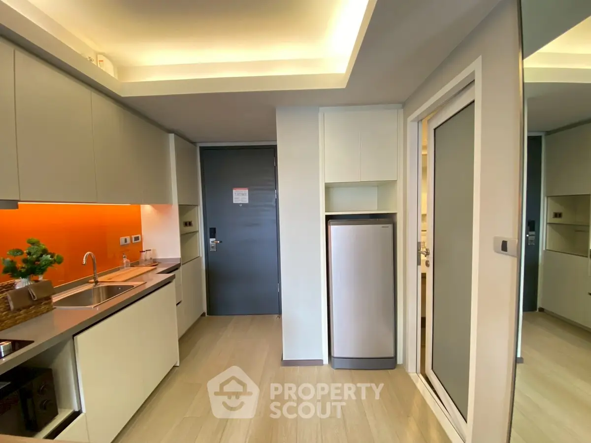 Modern kitchen with sleek cabinets and vibrant orange backsplash