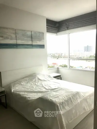 Modern bedroom with large window offering stunning city view in high-rise apartment.