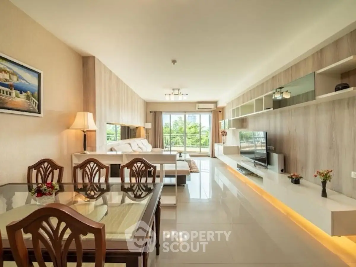 Spacious modern living room with elegant decor and large windows offering natural light.