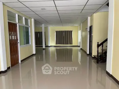 Spacious open-plan interior with glossy tiled floors and staircase, ideal for versatile living arrangements.