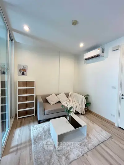 Modern living room with cozy sofa, stylish decor, and air conditioning in a bright apartment.
