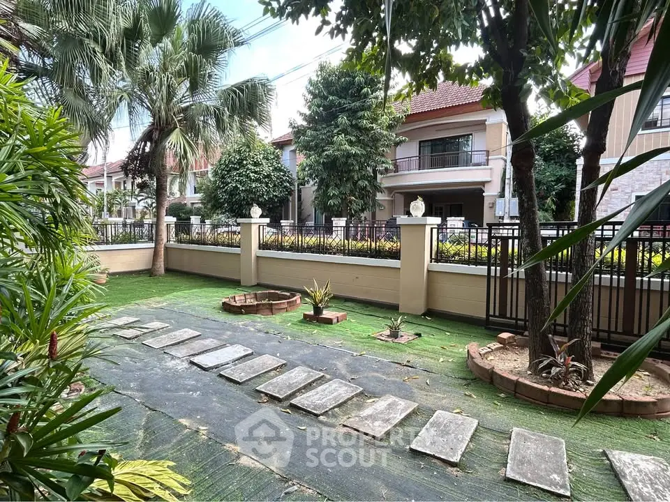 Charming garden view with lush greenery and pathway in a serene residential area.