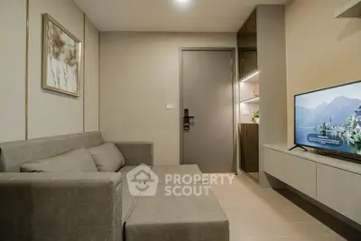 Modern living room with sleek furniture and wall-mounted TV in a stylish apartment.