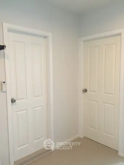 Minimalist interior with two white doors in a modern home setting.