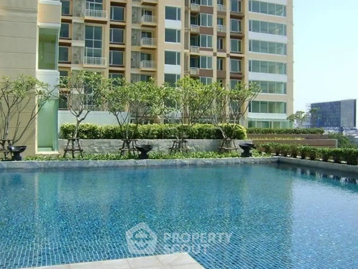 Luxurious residential building with serene pool and lush greenery, perfect for relaxation and leisure.