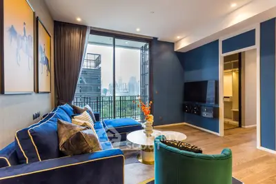 Luxurious living room with city view, elegant blue decor, and spacious balcony access.