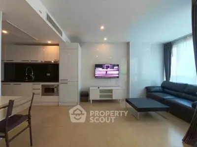 Modern living room with sleek kitchen and cozy seating area, perfect for urban living.