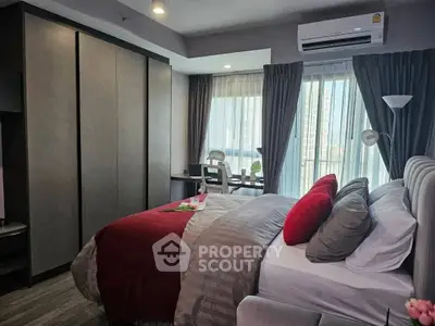 Modern bedroom with stylish decor, large windows, and a cozy workspace, perfect for urban living.