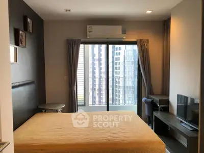 Modern bedroom with balcony view in high-rise apartment, featuring air conditioning and stylish furnishings.