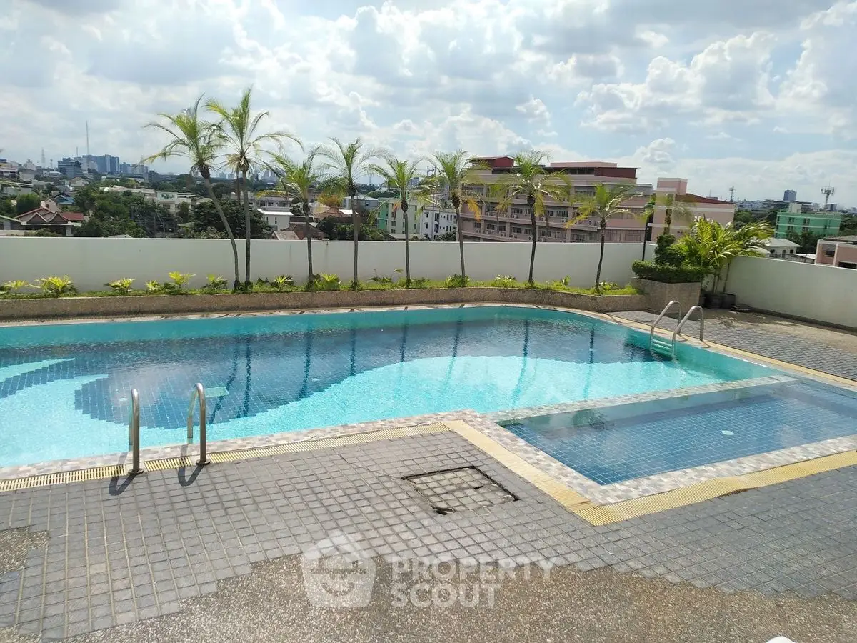 Stunning rooftop pool with city views and palm trees, perfect for relaxation.