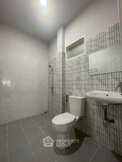 Modern bathroom with sleek tiles and contemporary fixtures.