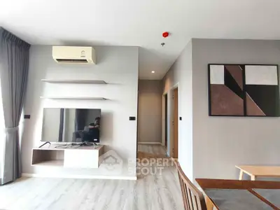 Modern living room with wall-mounted TV, air conditioning, and stylish decor in a contemporary apartment.
