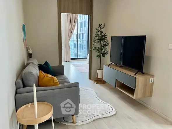 Modern living room with sleek TV setup and cozy sofa in stylish apartment.