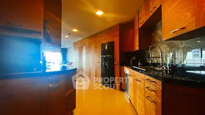 Luxurious kitchen with sleek wooden cabinetry and modern appliances in a spacious open layout.