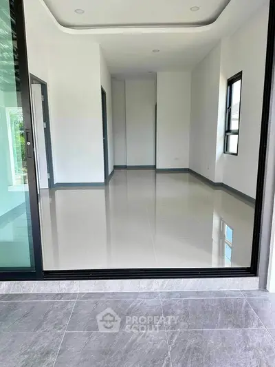 Spacious modern interior with sleek flooring and large windows, perfect for natural light.