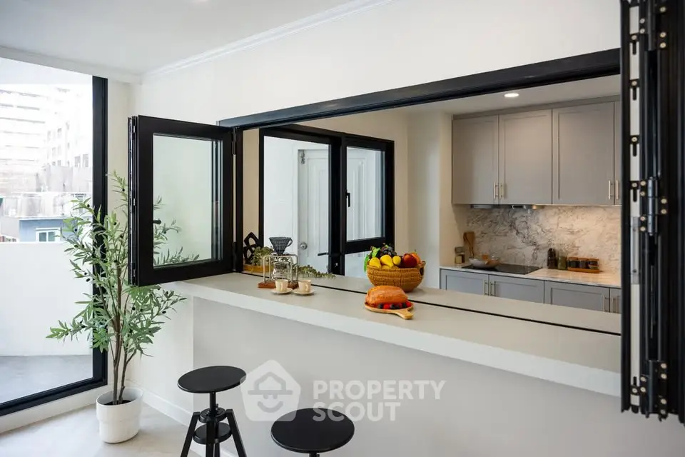 Modern kitchen with open layout and stylish breakfast bar overlooking city view.