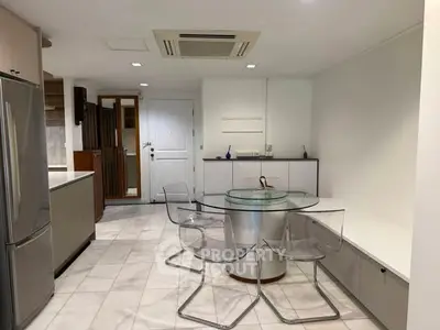 Modern kitchen with sleek design and glass dining table in open layout