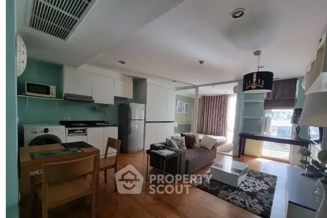 Spacious modern living room with open kitchen and large windows in a stylish apartment.