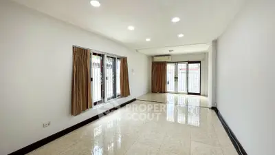 Spacious living room with large windows and tiled flooring in a modern home.