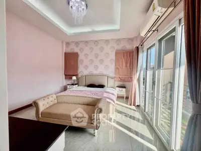 Luxurious bedroom with elegant decor and ample natural light from large windows.