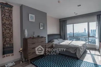 Spacious bedroom with city view, modern decor, and natural light.