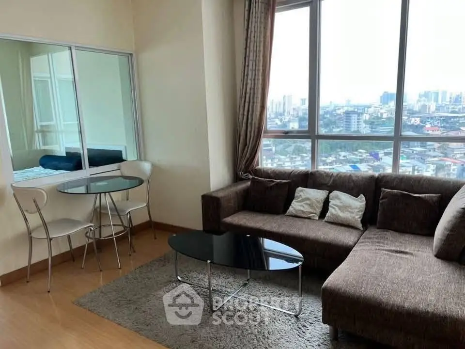 Modern living room with city view, featuring a cozy brown sofa and glass dining table.