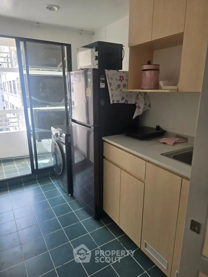 Modern kitchen with sleek appliances and balcony access in a stylish apartment.